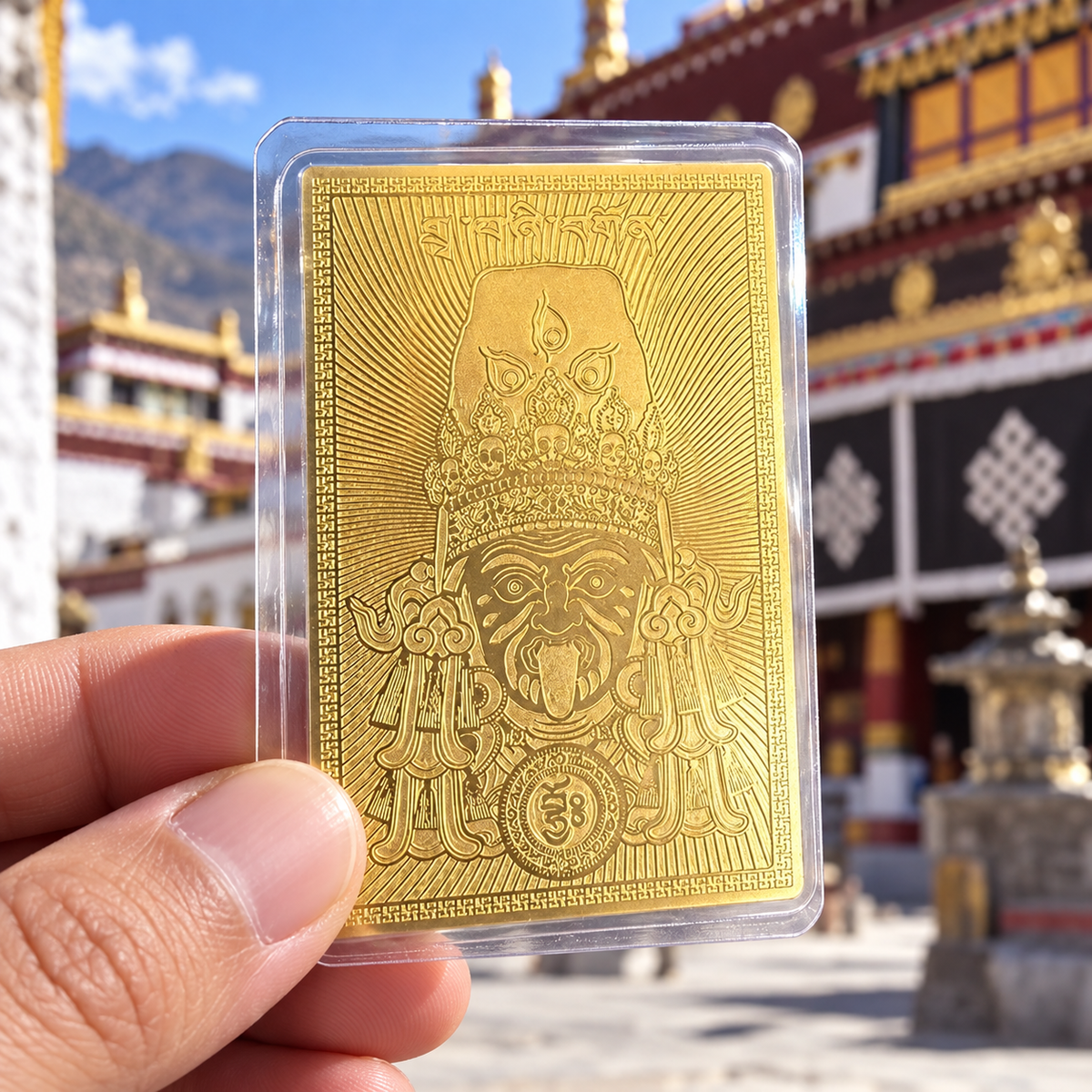 Hand holding a Zaki Lhamo prosperity gold card in front of a Tibetan monastery